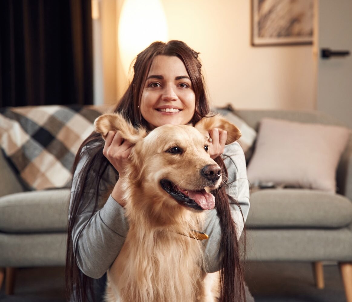 A woman playing with her dogs ears