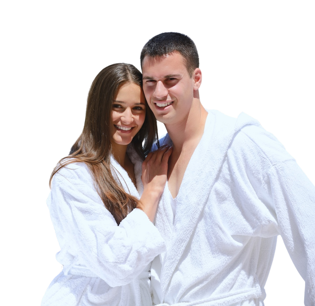 A couple in robes smiling for the camera because they got a honeymoon loan
