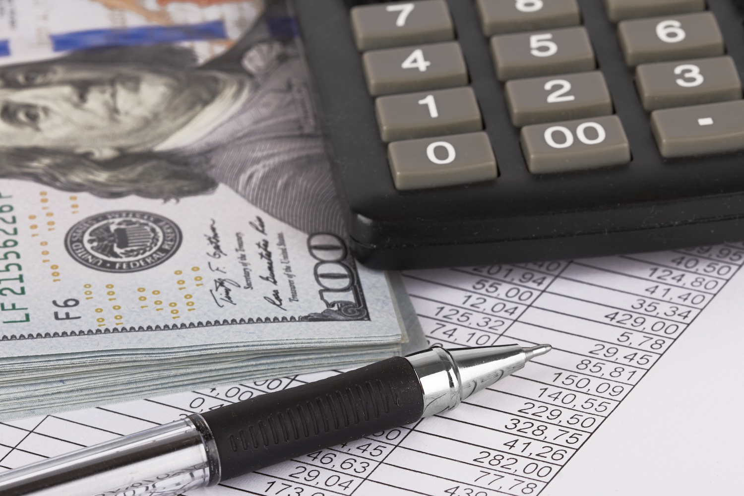 Dollars, a calculator and a spreadsheet to represent ‘Can I refinance my personal loan?’.