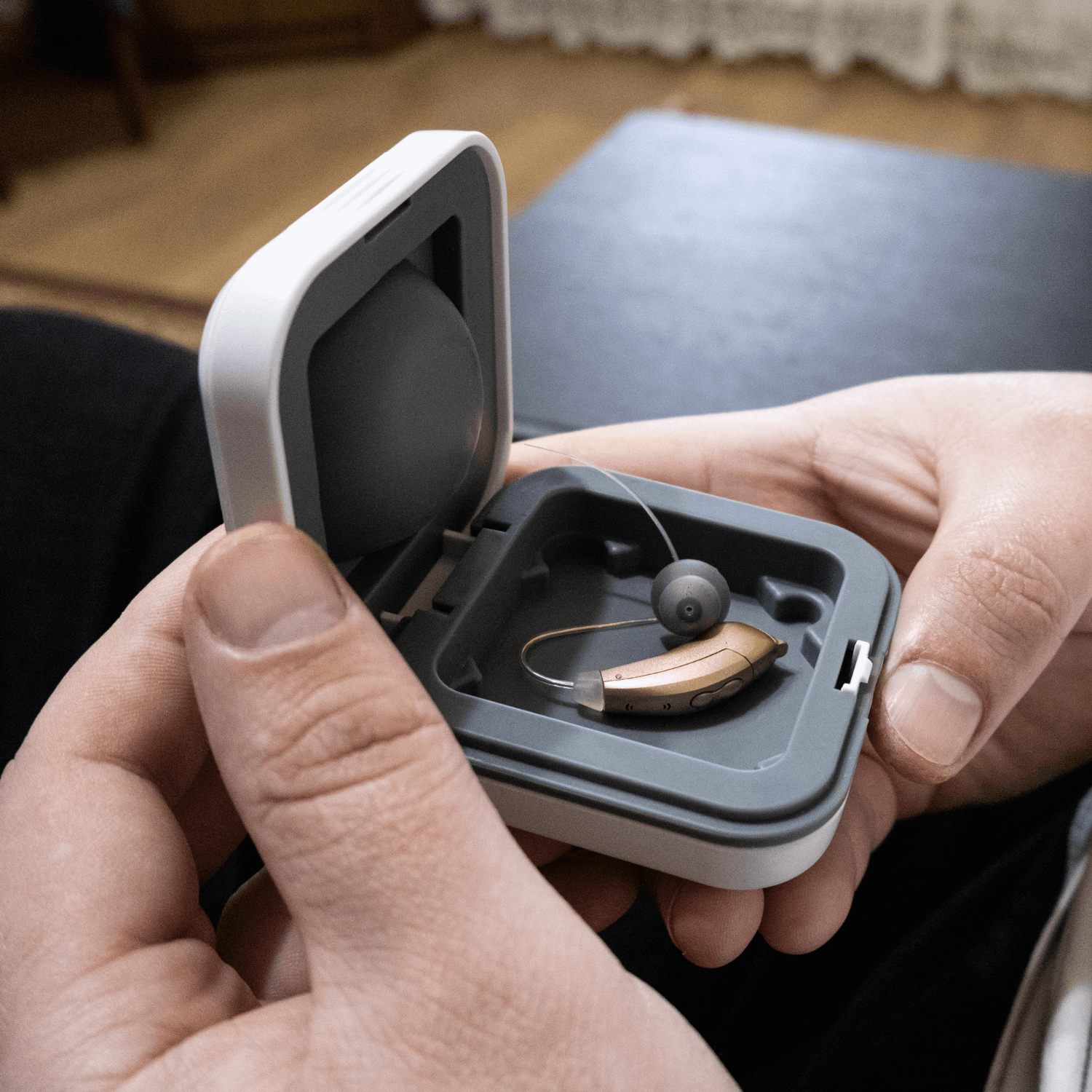 Someone holding a hearing aid in a box to represent hearing aid loans