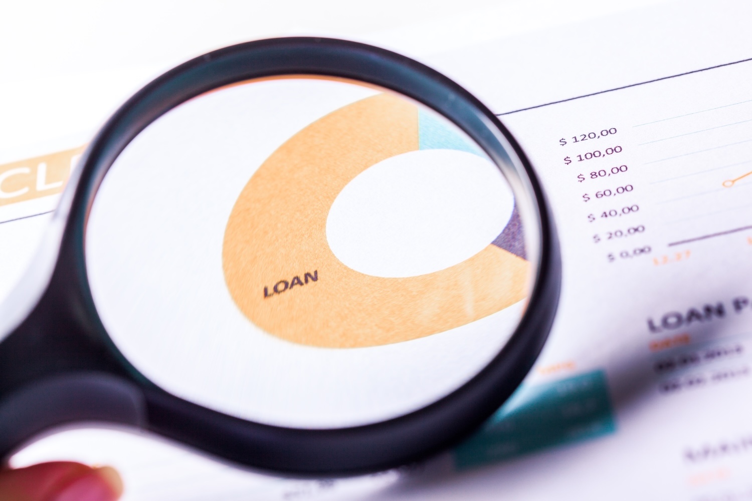 A magnifying lgass looking at interest on a spreadsheet to represent 'How does interest work on a personal loan?'