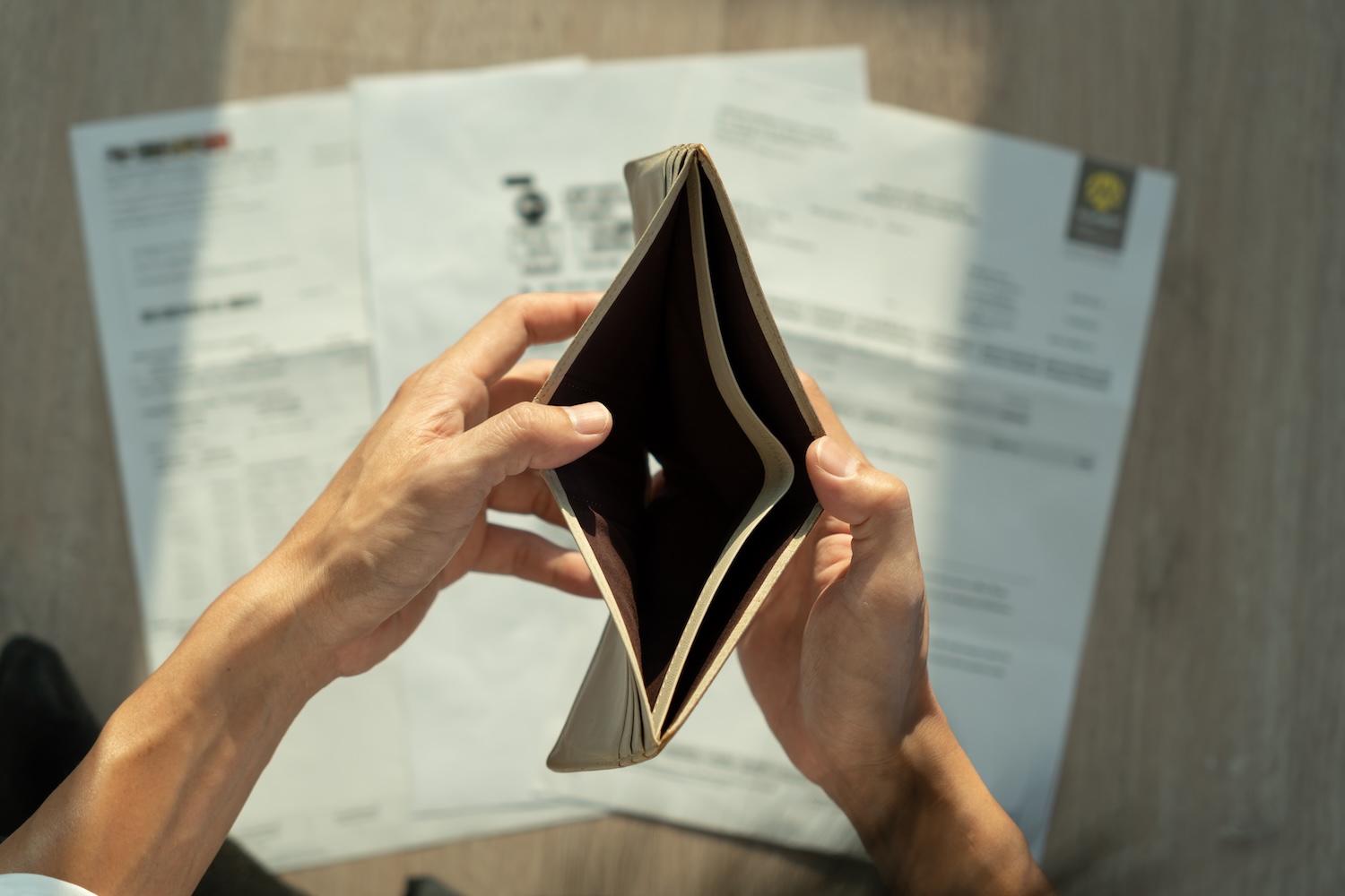 A man holding an empty wallet open wondering: does bankruptcy clear personal loans