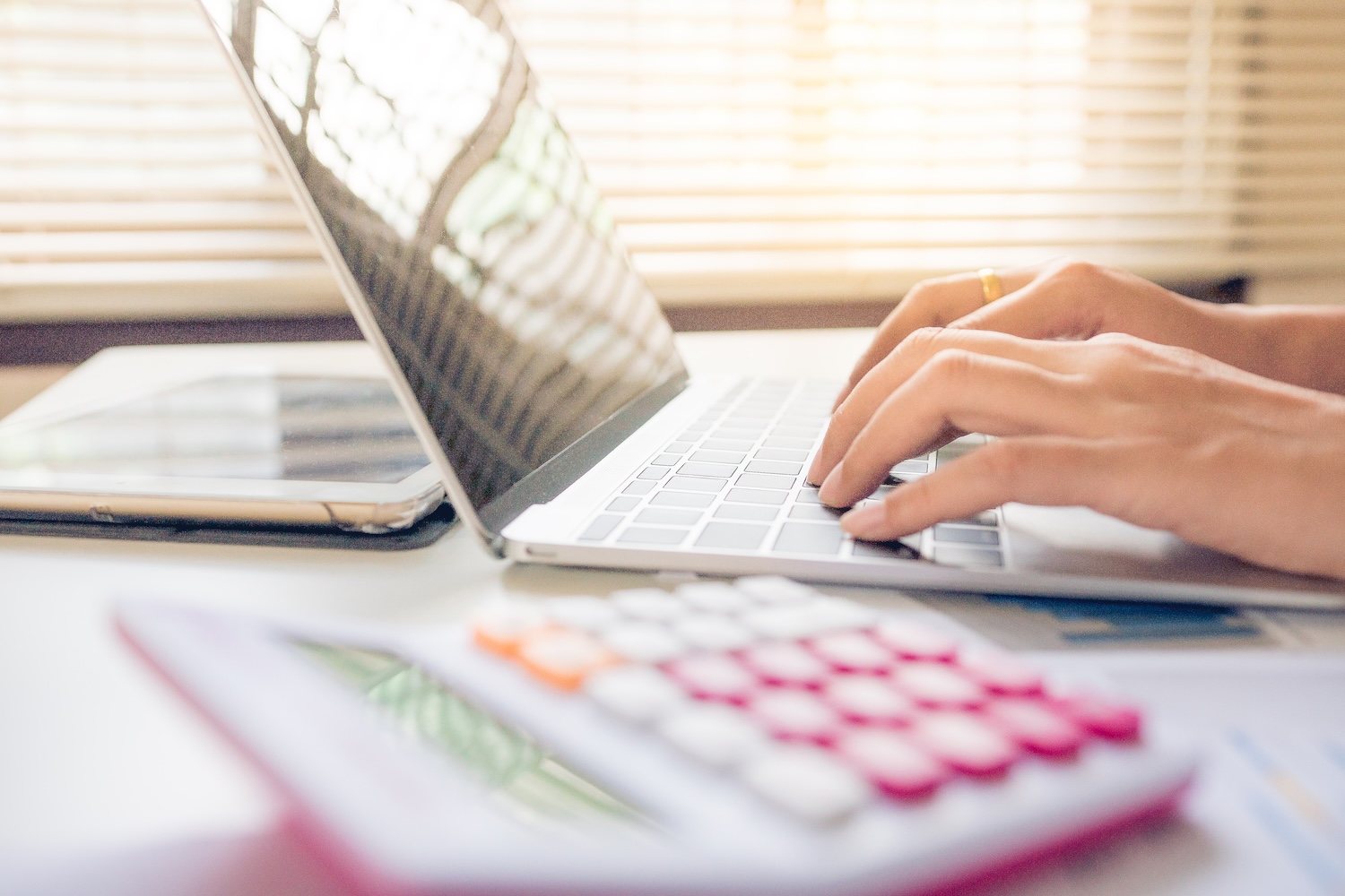 A person typing on a laptop searching for how to get a personal loan with low interest