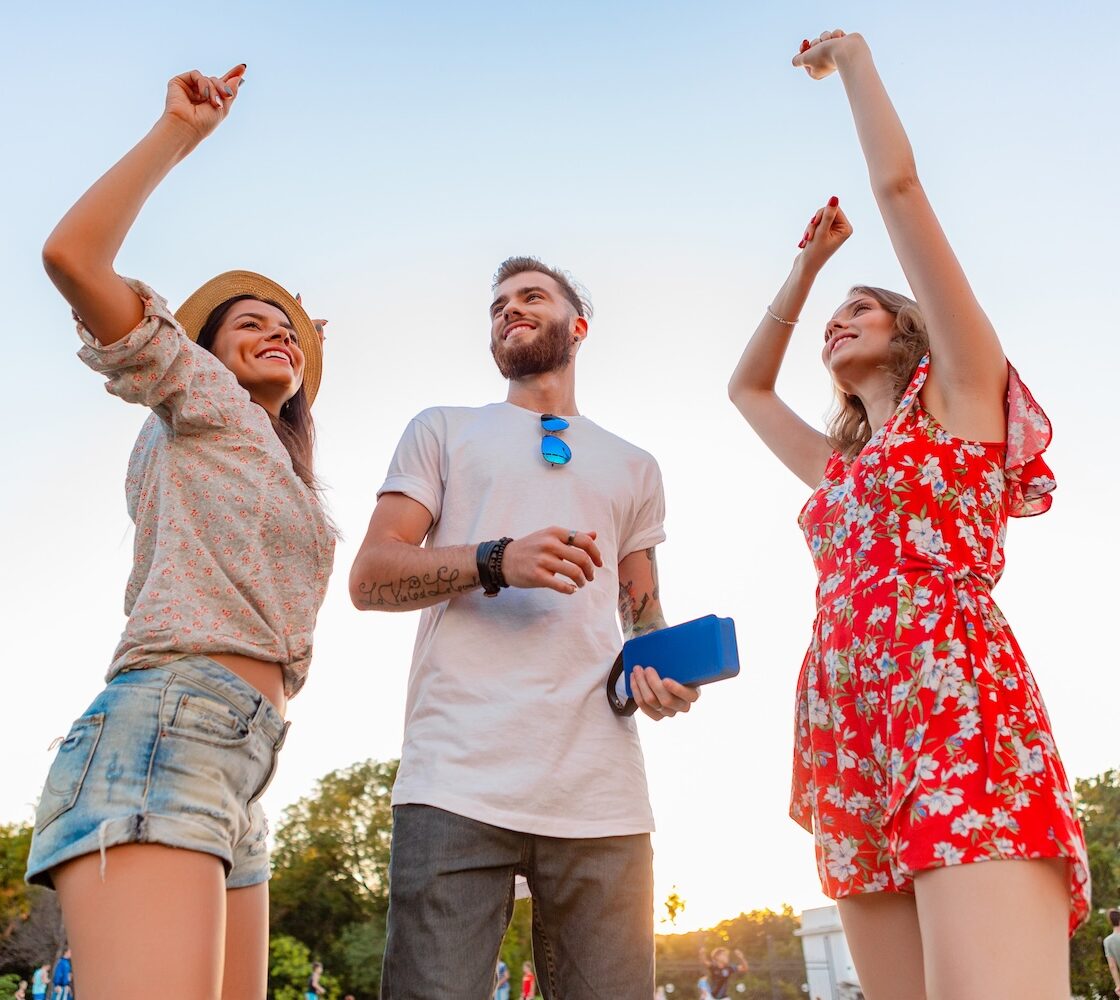 A man and two women dancing at a music festival